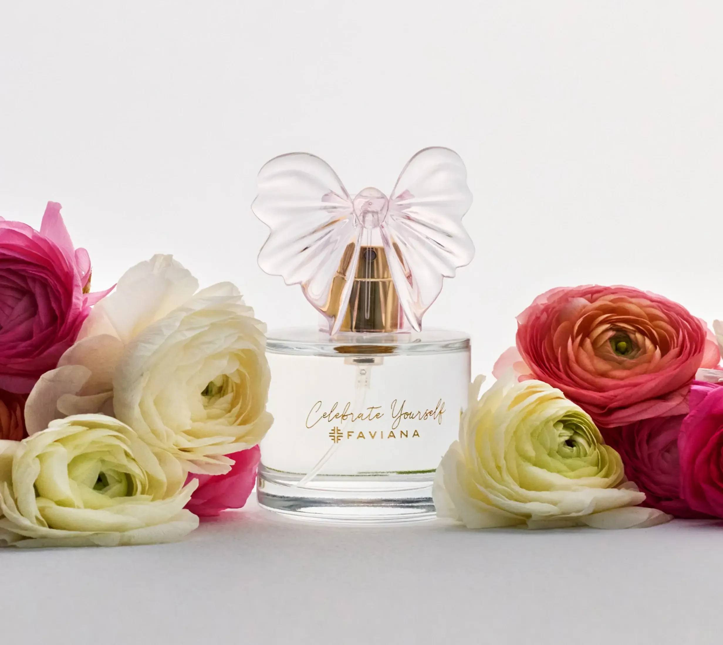 Faviana Celebrate Yourself fragrance bottle surrounded by colorful flowers.